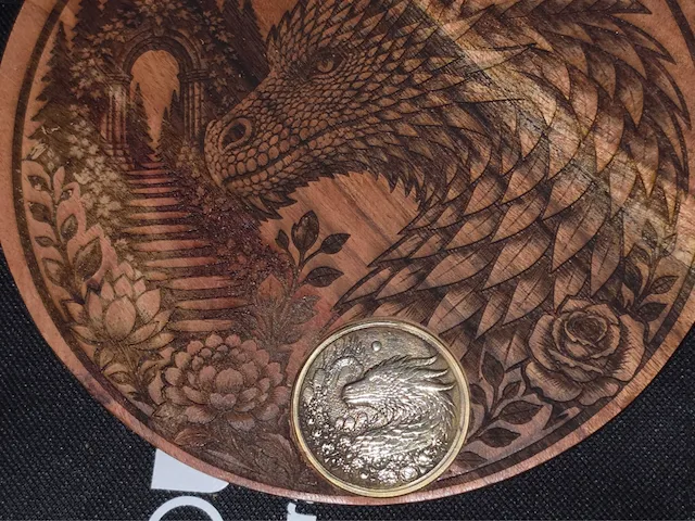 Round wooden plaque featuring a detailed dragon and floral landscape illustration