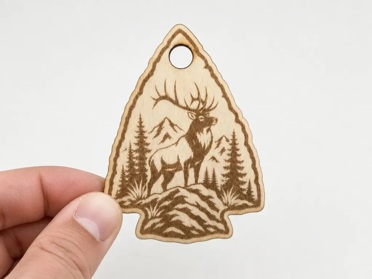 [Laser cut and engrave] Arrowhead Shaped Wooden Ornament Featuring an Elk in a Mountain Forest