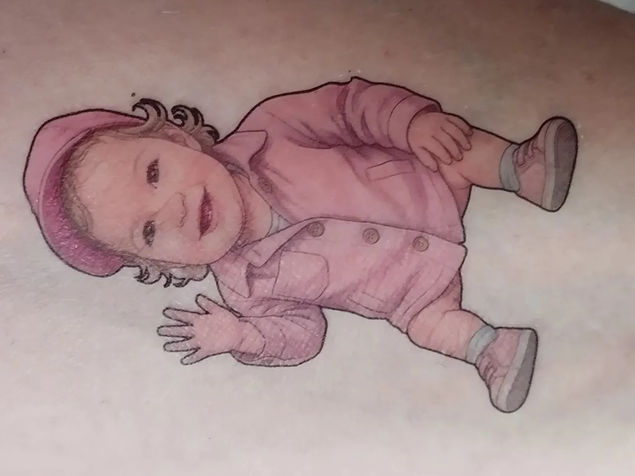 [Inkjet printing] Tatouage réaliste représentant un bébé portant un bonnet et une tenue rose