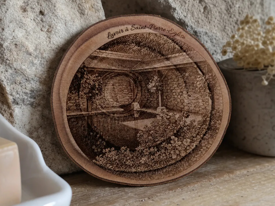 Disque en bois de pin illustrant le lavoir à Saint-Pierre-Église