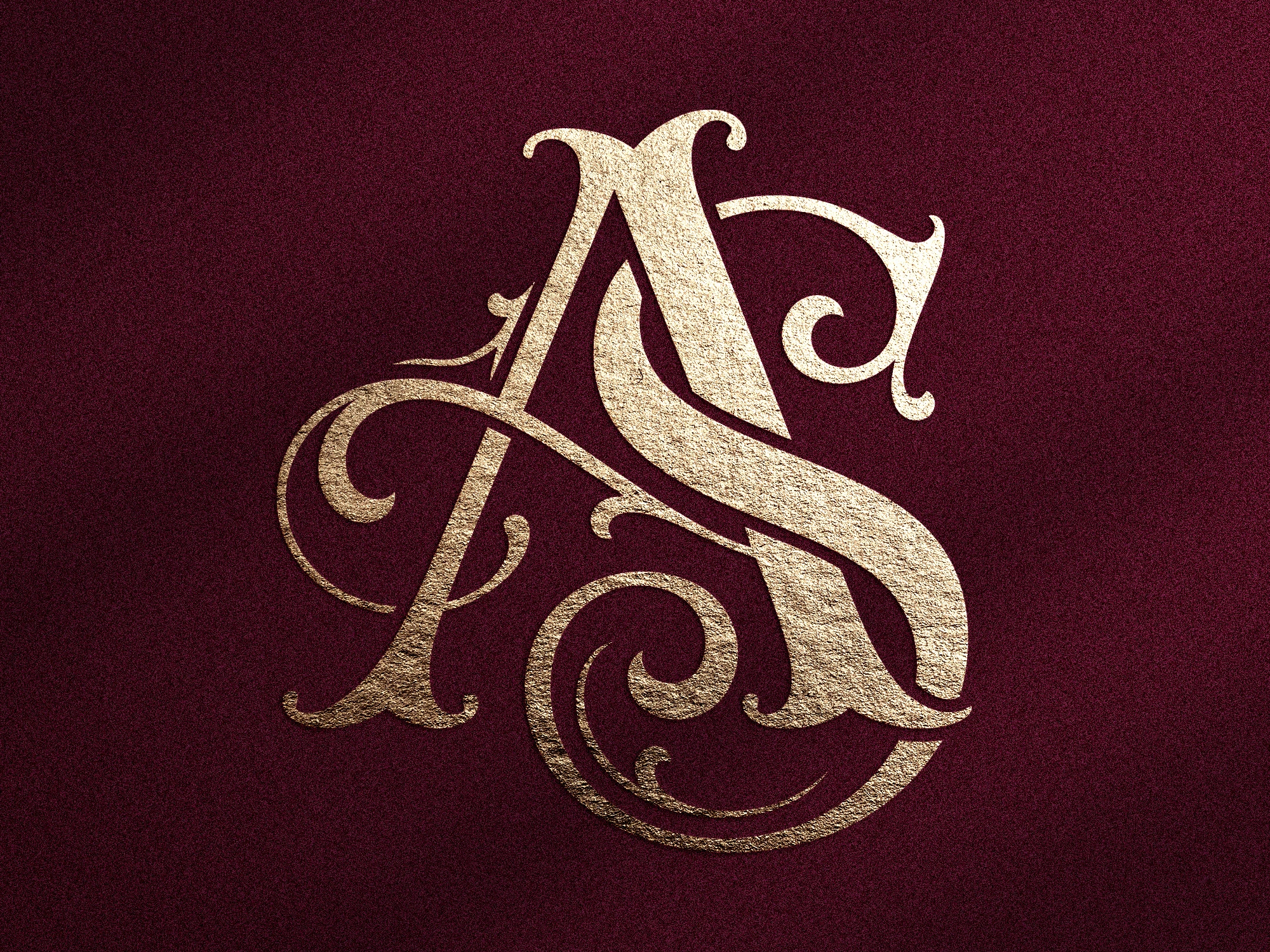 Monogramme doré avec les lettres A et S sur fond texturé bordeaux