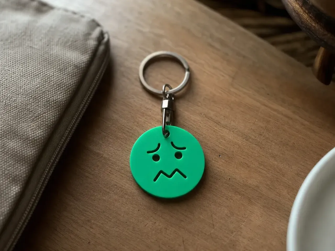 [Laser cut and engrave] Zelená klíčenka s motivem smutného obličeje