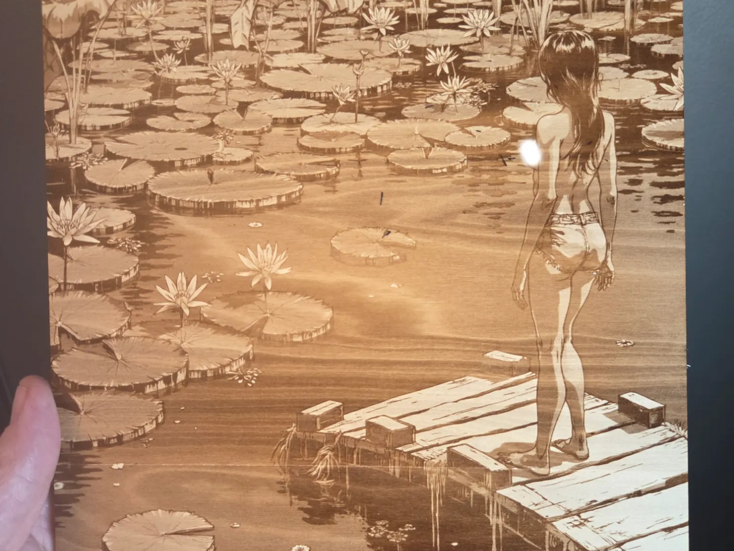 Wooden wall art featuring a woman standing on a dock in a lily pond