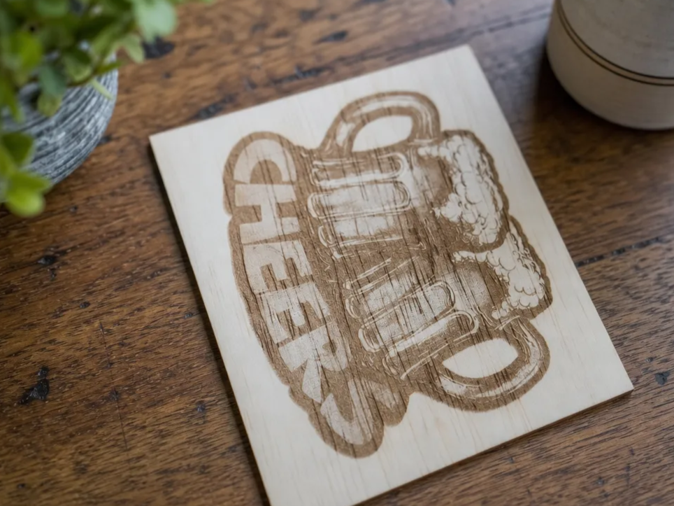 Posavasos de madera con diseño de jarras de cerveza y texto cheers