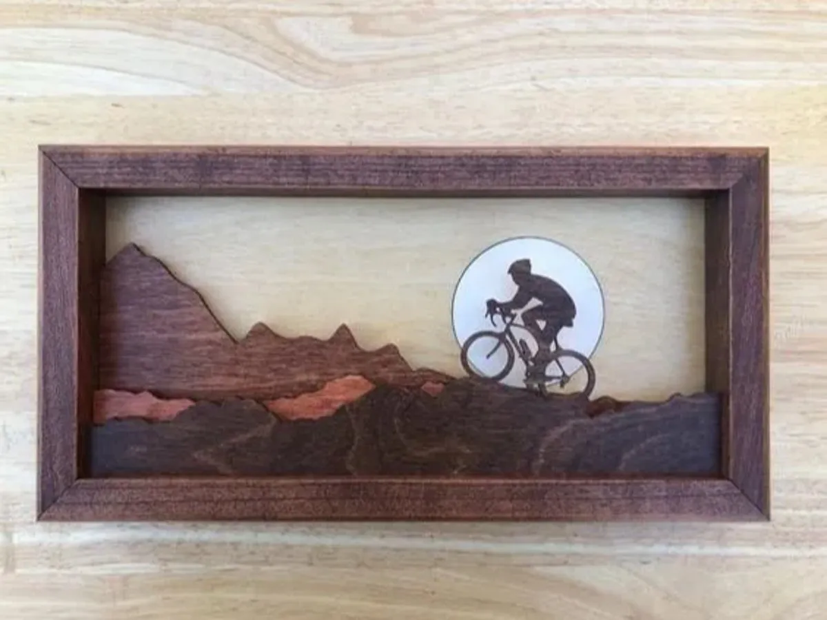 [Laser cut and engrave] Layered Wood Wall Art Featuring a Cyclist Riding Through Mountain Landscape