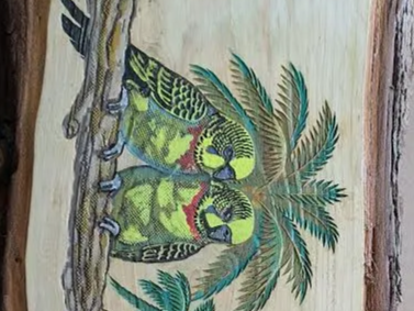 Tableau en bois représentant deux perruches sur une branche avec un palmier