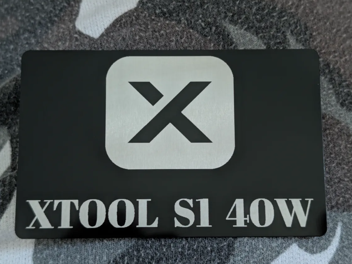 Schwarze Metallkarte mit X-Logo und XTOOL S1 40W Beschriftung