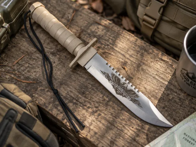 Tactical survival knife with eagle emblem and serrated blade