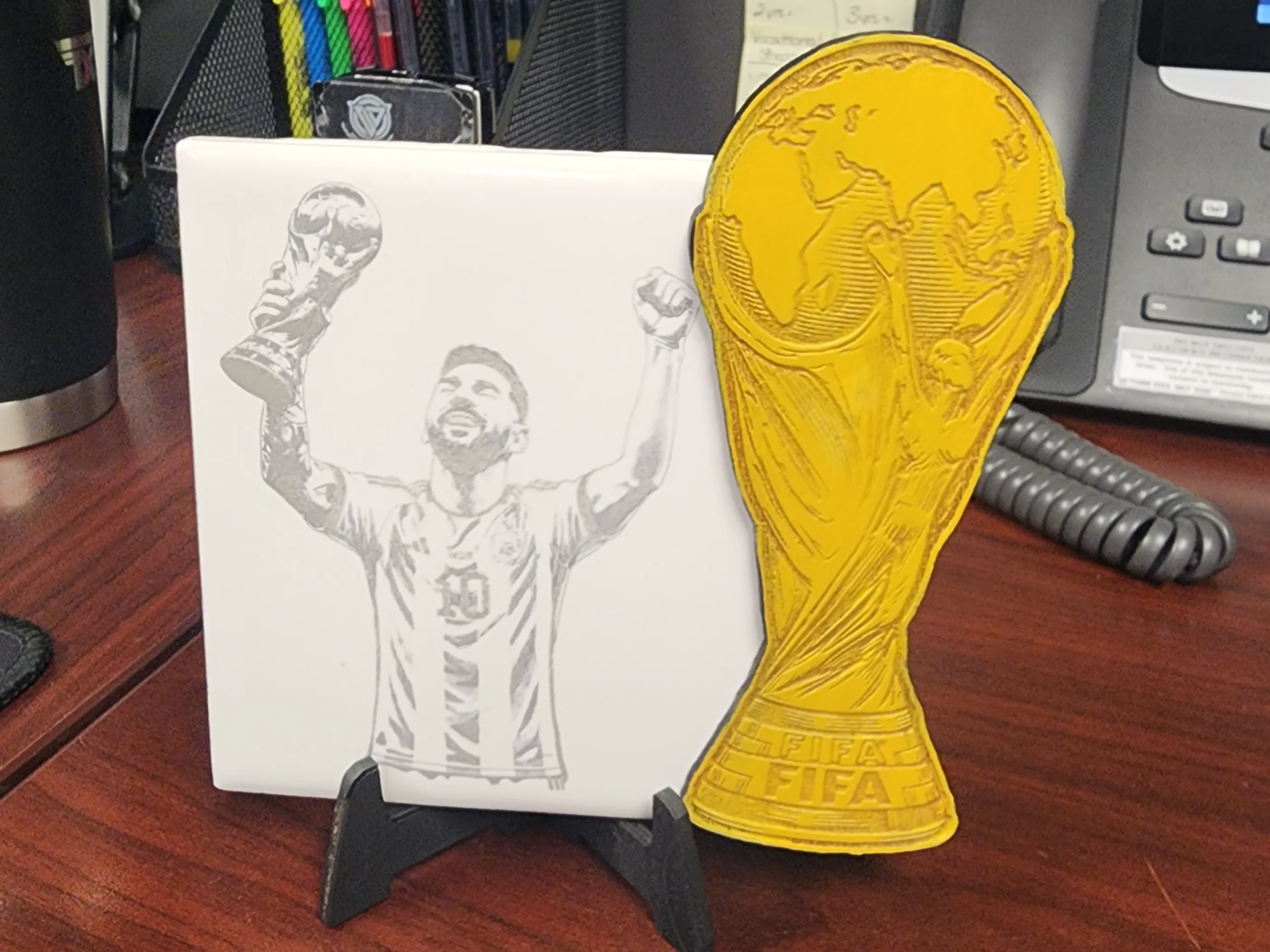 Lionel Messi holding World Cup trophy ceramic tile and gold trophy cutout