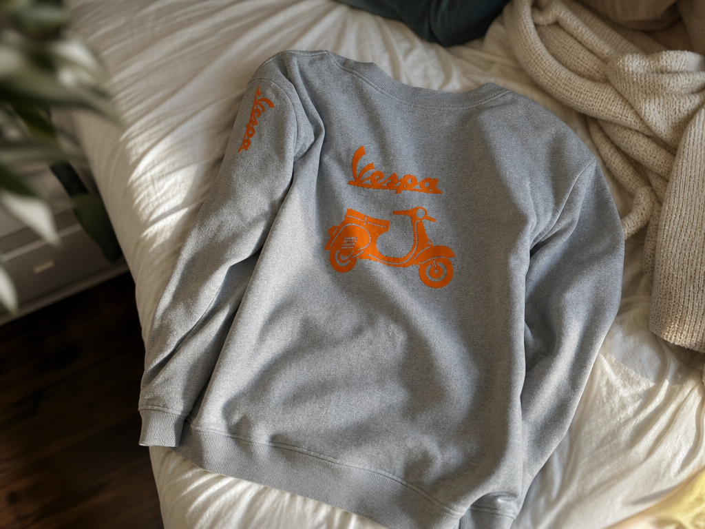 Grauer Pullover mit orangefarbenem Vespa Roller Motiv