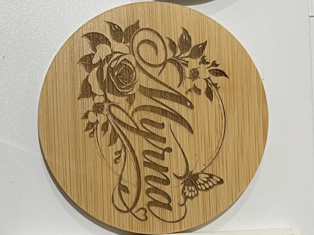 [Laser cut and engrave] Round Wooden Coaster Featuring Myrna Name with Floral and Butterfly Motif