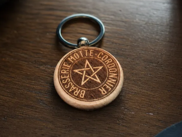 Porte-clés rond en bois avec logo Brasserie Motte-Cordonnier et étoile