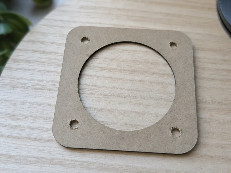 Plaque carrée en bois avec ouverture circulaire et trous de fixation