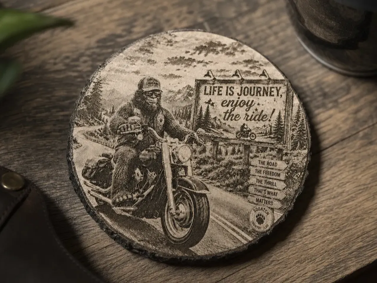 [Laser cut and engrave] Bigfoot Riding Motorcycle Round Slate Coaster with Life is a Journey Enjoy the Ride Quote.
