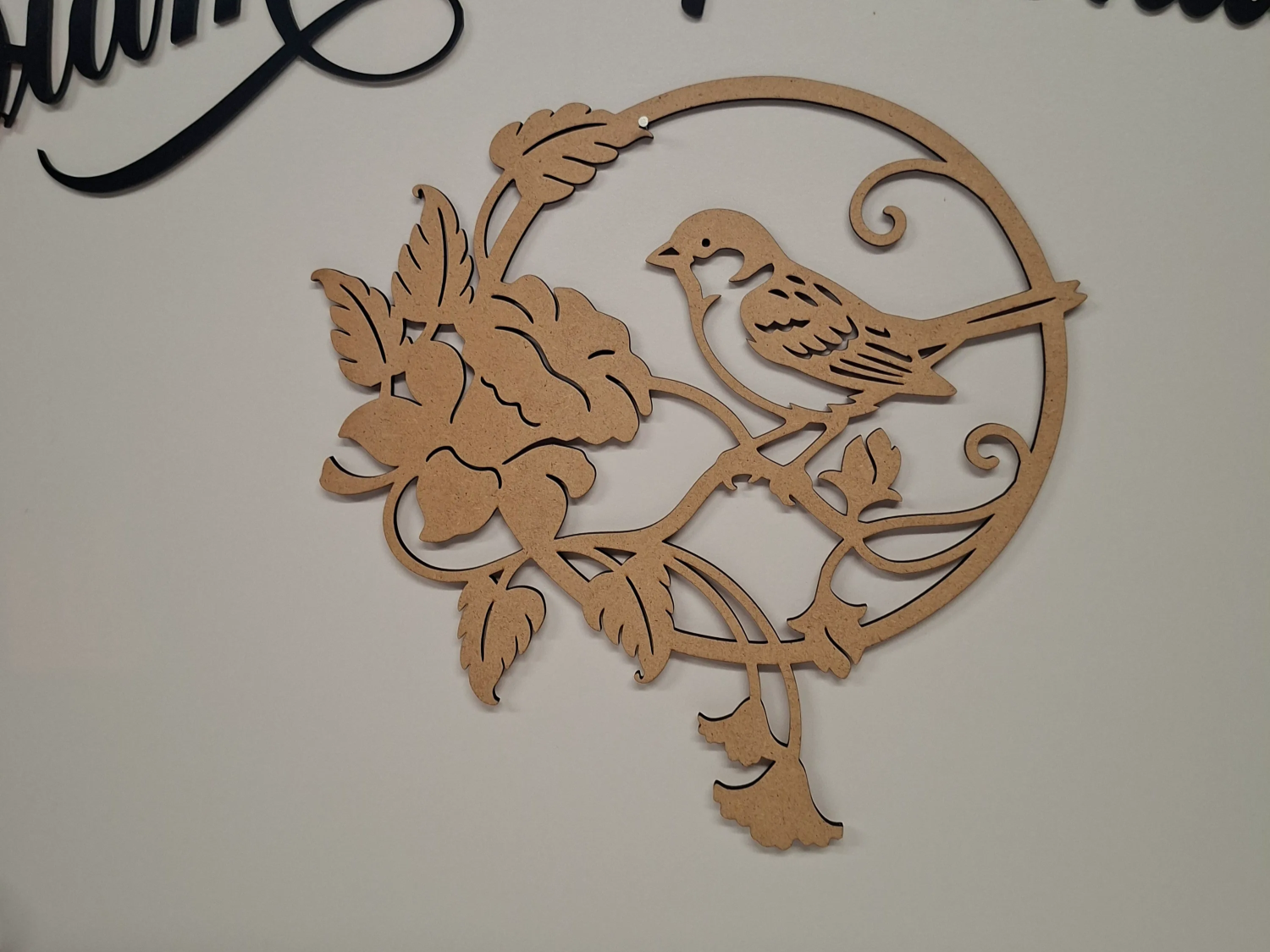 Circular wall hanging featuring a bird and flower motif