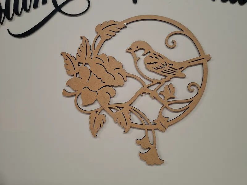 Circular wall hanging featuring a bird and flower motif