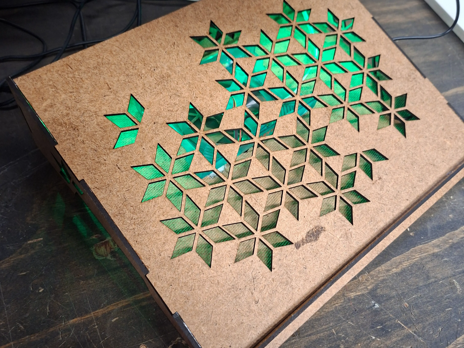 Light-up laptop stand with geometric snowflake pattern and green LED illumination