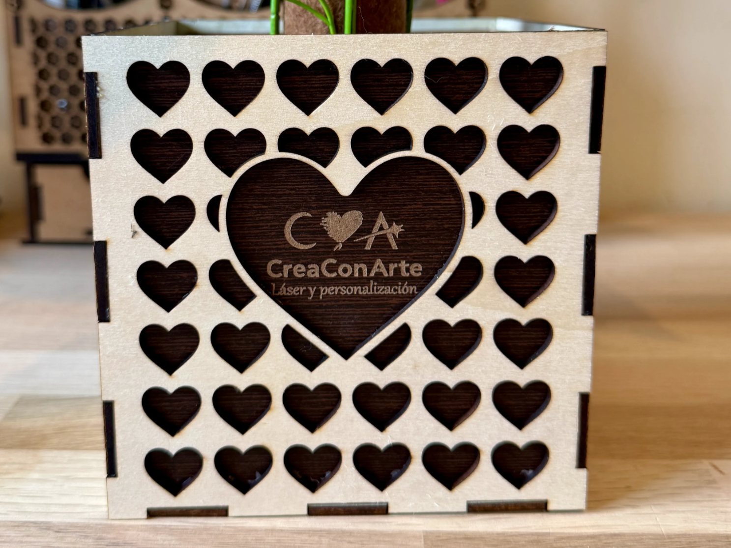 Square wooden planter box with heart cutout pattern
