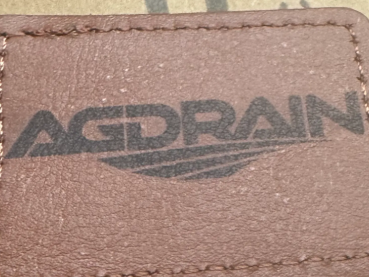 Brown leather patch with AGDRAIN logo