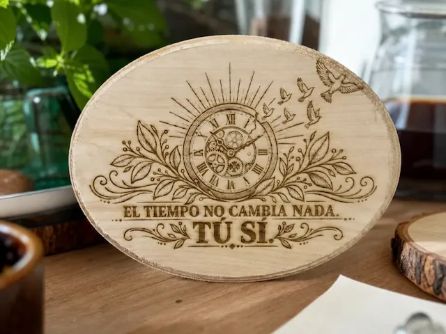 Placa ovalada de madera con diseño de reloj y frase motivacional