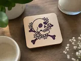[Laser cut and engrave] Square Wooden Coaster Featuring a Floral Skull and Crossbones Design