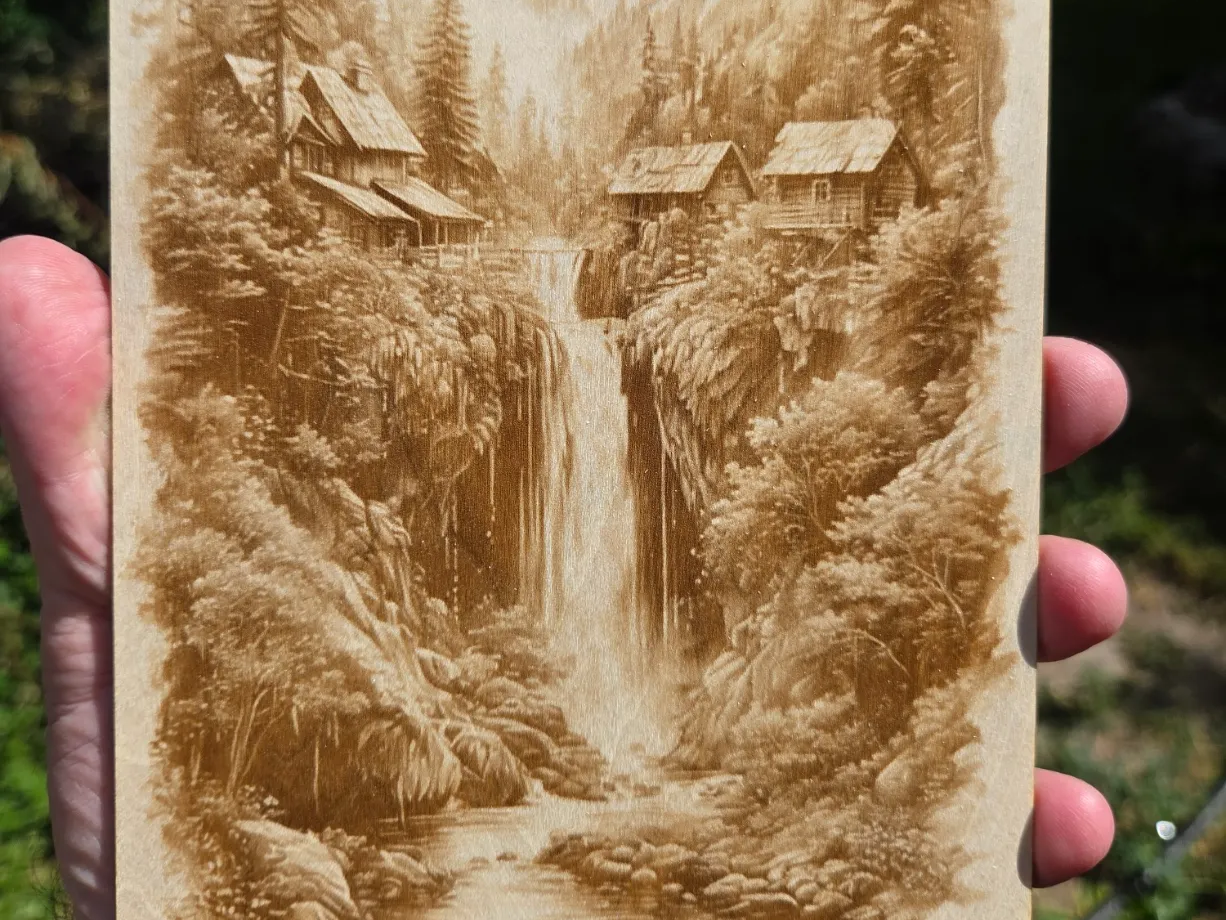 Wooden Plaque Featuring a Scenic Mountain Waterfall and Rustic Cabins