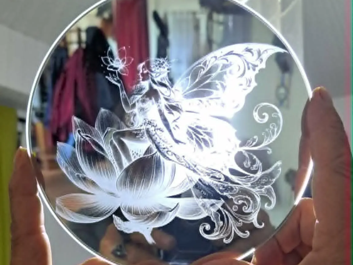 gravure sur mirroir rond representant une fée assise sur une fleur de lotus