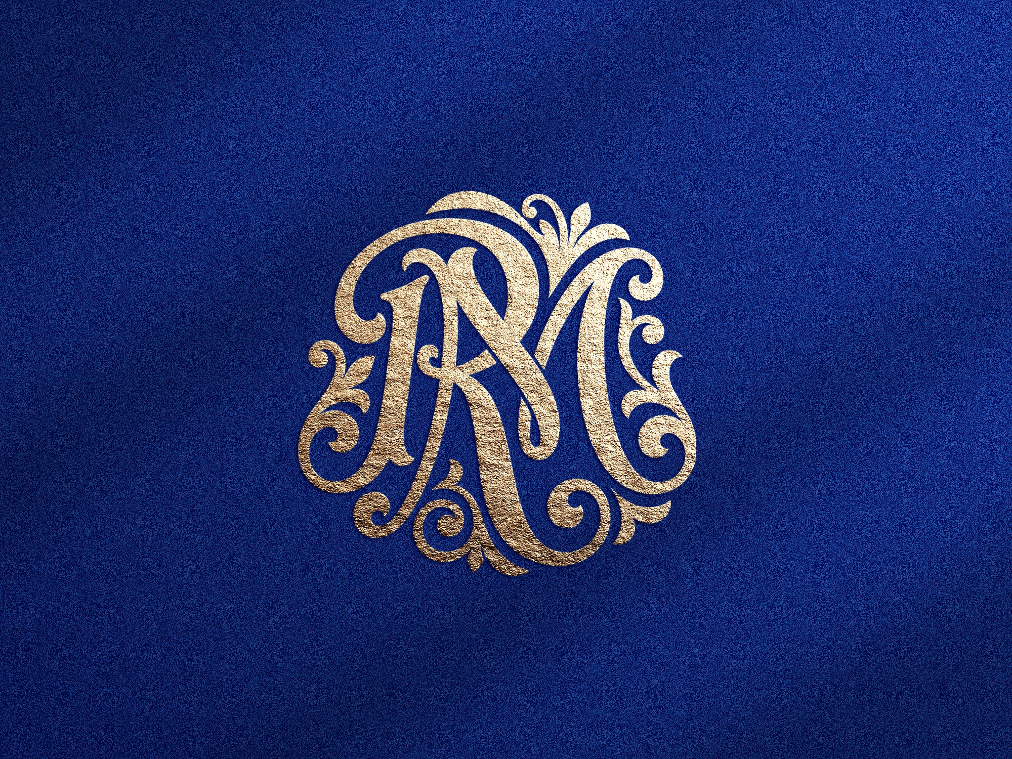 Monogramme doré RM avec ornements floraux sur fond bleu texturé