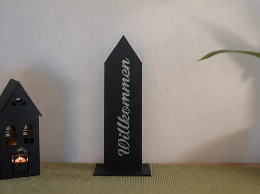 Schwarzes Willkommensschild in Hausform als Tischaufsteller
