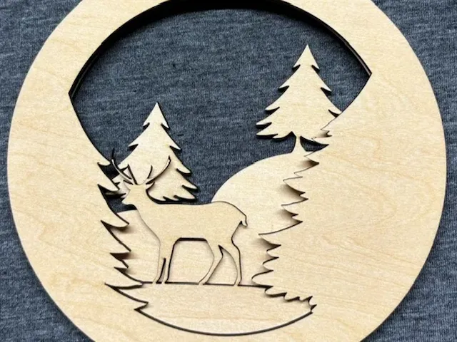 Circular Wooden Wall Hanging Featuring a Deer in a Forest Scene