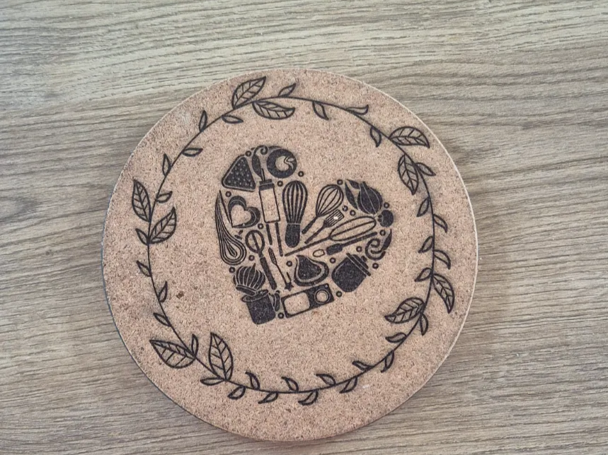Dessous de plat en liège avec motif de cœur composé d'ustensiles de cuisine